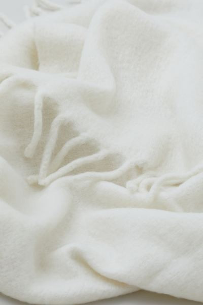 Soft throw in double layers of woven fabric with wool content and a brushed finish. Large fringe ... | H&M (US + CA)