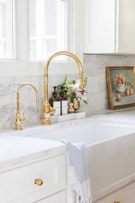 Unlacquered brass kitchen faucet and hot water tap. Kitchen sink, fireclay sink, marble countertop, amber soap bottles 

#LTKhome #LTKFind #LTKSeasonal