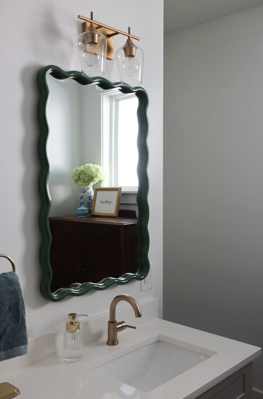 This Jack and Jill bathroom makeover is proof that kids’ spaces can be both practical and beautiful.✨ Designed to grow with two young boys, the room now feels playful yet refined — filled with vintage charm, layered color, and thoughtful details. We mixed classic elements with fun touches like green scalloped mirrors, teal gingham curtains, and whimsical artwork to bring in personality without feeling too young. A dark wood storage cabinet adds warmth and function, while gold hardware gives the space a polished, timeless finish. The result is a joyful, character-filled bathroom that feels elevated, charming, and designed to last through every stage.💚🛁 

 #kidsbathroomdesign #vintagestyle #timelessinteriors #LTKHome #LTKKids #LTKFamily