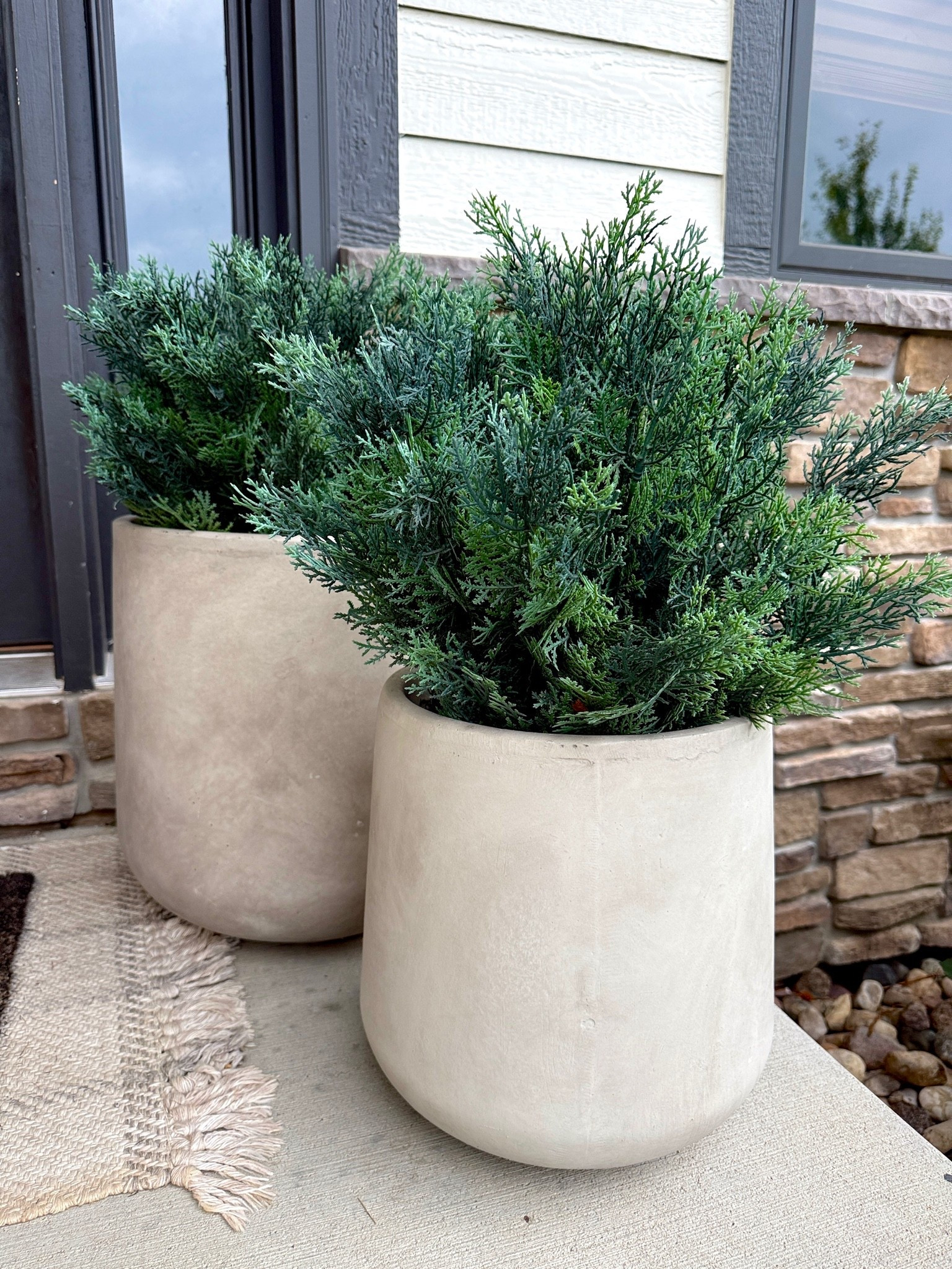 2 years later and it has still been one of the best investments I’ve made to our front porch. Zero maintenance and looks so elevated and real! The concrete planters come in a set of 3 different sizes and the artificial cedar bushes look SO real. I lined the pots with rocks for extra weight and support and that’s it! Amazing Home Decor that’s affordable and functional.

#LTKHome #LTKSeasonal