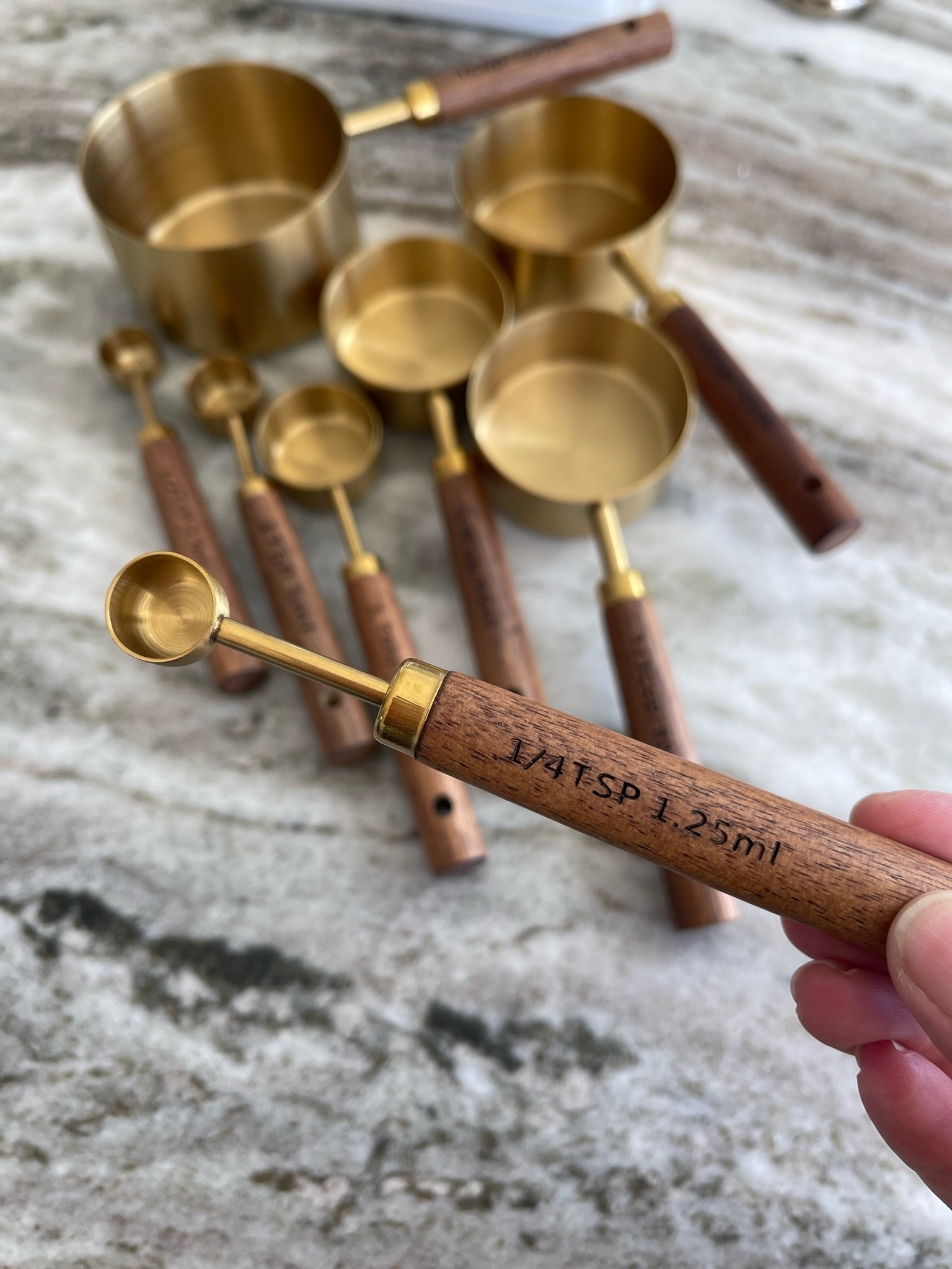 Brass and wood measuring cups and measuring spoons.

#LTKdayinmylife #LTKfoodie #LTKHome