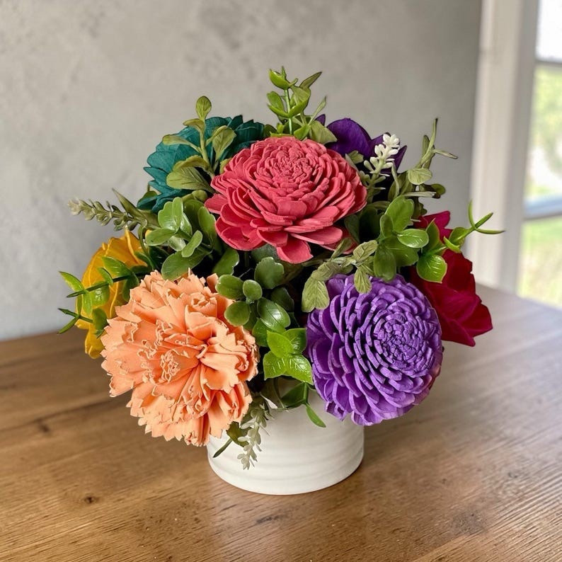 This petite sola wood flower arrangement adds a warm, natural touch to any shelf, desk, or tabletop. Handcrafted from the root of the tapioca plant, each bloom features soft ivory petals with subtle earthy tones that highlight the beauty of natural materials. Carefully dyed, fluffed, and arranged by hand, this charming piece makes a thoughtful gift or a lasting floral accent that brings cozy texture to your home décor. #LTKhome #solawoodflowers #handmadehome #rusticdecor #naturaldecor #giftideas #floraldecor #neutraldecor #homestyling #artisanmade

#LTKHome #LTKWedding #LTKSeasonal