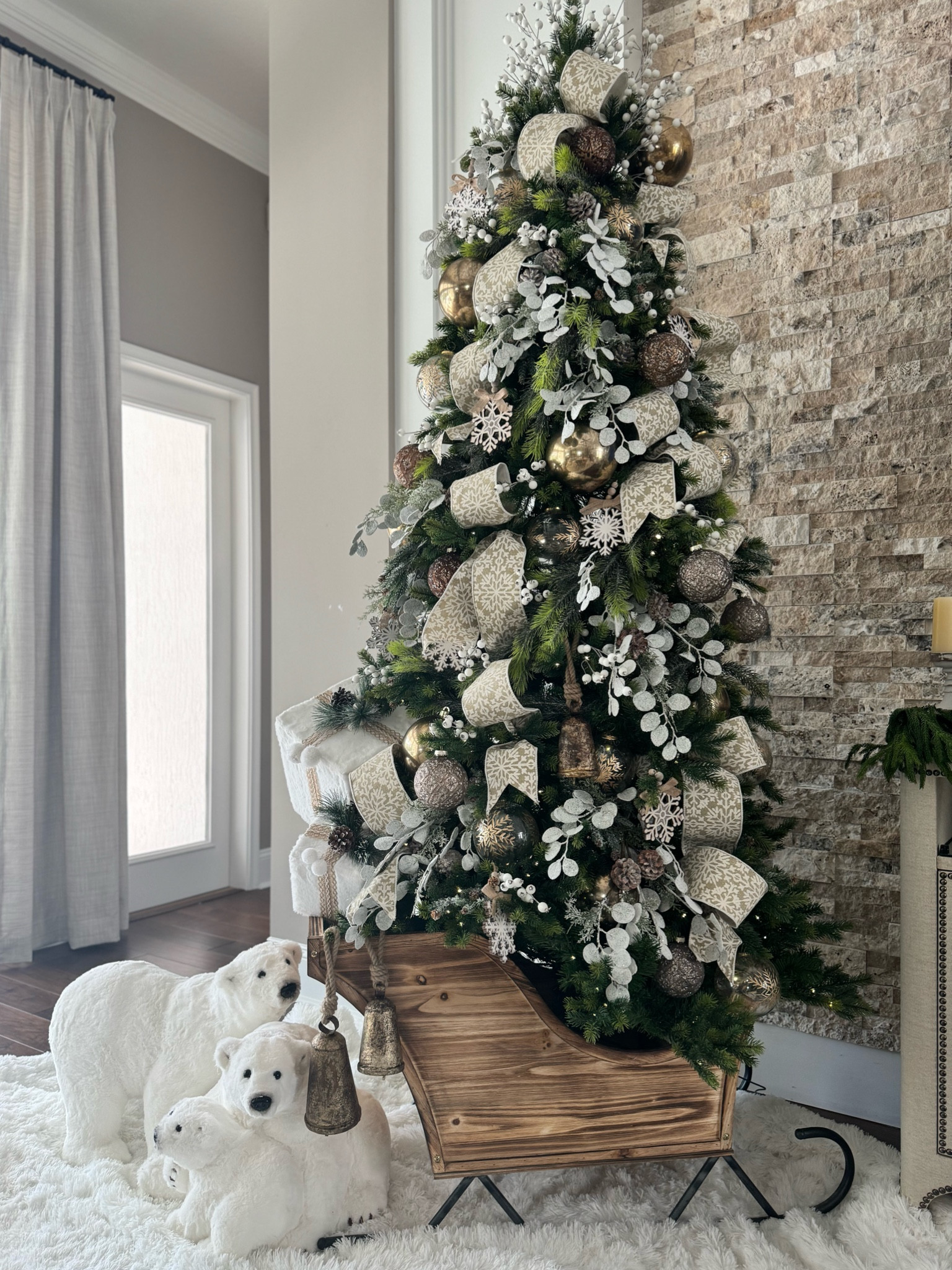 This sleigh immediately gave off “Tree Stand” vibes! It’s a beautiful piece with incredible quality. The most important tip I can give if you plan to use it this way is to measure your tree stand first. The sleigh’s base size is 17” wide x 21” and our 22” stand fits in it perfectly on angle. 

Here’s what I used to create this look:

	•	Flocked picks to give the tree a snowy effect
	•	Frosted eucalyptus picks for added texture
	•	4” wired sparkly snowflake ribbon (Tip: each roll is 5 yards long. I recommend getting at least 4 rolls)
	•	A queen-size white fluffy comforter to create a snowy base under the sleigh
	•	Metal bells hung off the side of the sleigh, which can also be placed throughout the tree
	•	Adorable polar bears (currently unavailable, but I’ll let you know as soon as they’re back in stock!)

The ornaments? Absolutely stunning, and all from Sullivans! 
.
.
.
.
#christmastreedescor #christmastreeidea #christmasdiy #christmasornaments #christmastreestand #holdmyeggnog

#LTKSeasonal #LTKSaleAlert #LTKHome