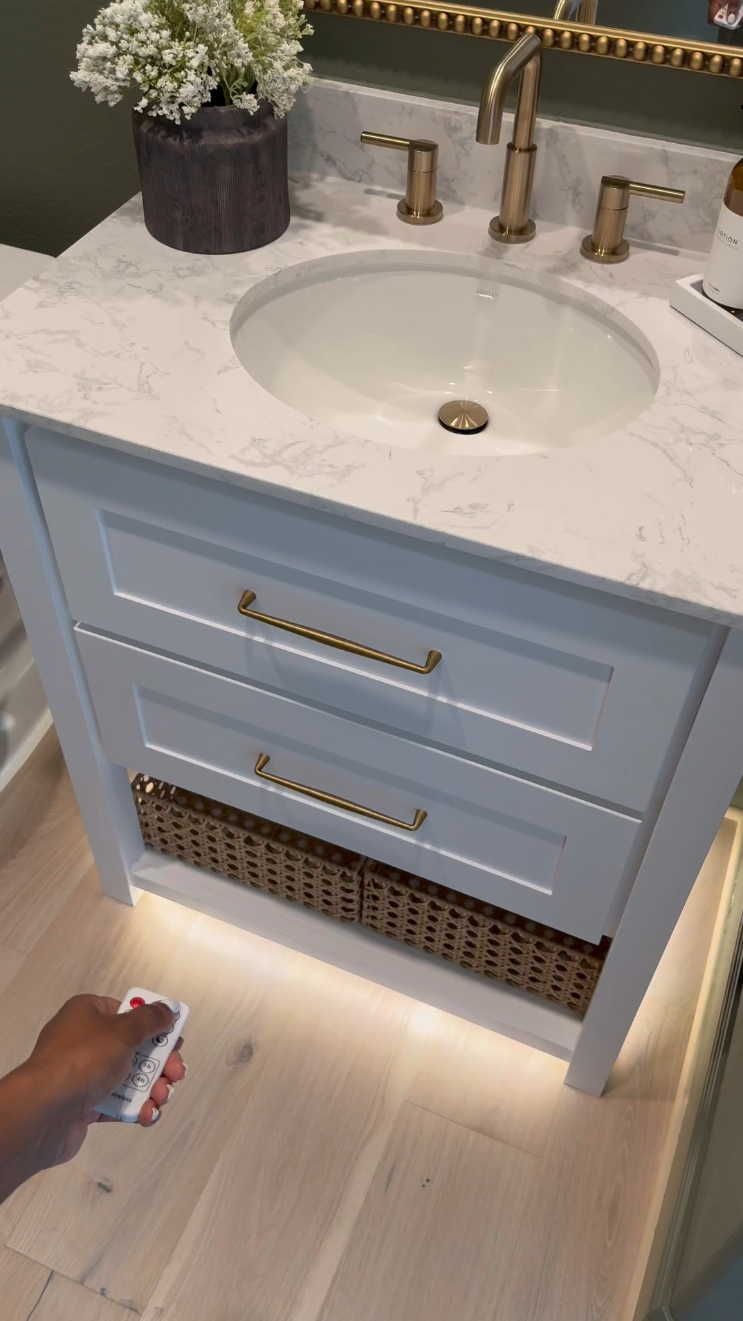 If you’re considering painting your powder room green, I’m telling you, THIS might be the perfect color for you … go for it! 

I used flat finish for the walls and painted the baseboards in satin finish… 

I’ll be honest, I was apprehensive at first … I even paintings the ceiling 😬 believe it our not, it made the room feel larger! 

I chose brass finishes bc I really wanted the space to have a vintage feel… well, modern vintage…??? If that’s a thing 😆.. 

The mirror is 30x40 inches… 

I added a new light fixture and it now faces upwards … which made that wall feel taller 

I wasn’t in love with this builder grade vanity tbh😆, matter-fact, I wanted to change it… it wasn’t functional …but now i wanna keep it lol 😂… I added brass hardware, these cute baskets from Walmart, led light strips on the bottom and now it’s a whole new unit….. you can even add battery powered/rechargeable/plug in led light strips .. whatever fits your lifestyle 

Ok let’s talk about this stunning planter!!! …. You know I love me an olive tree 😆… and I wanted something tell and slim… this planter was the perfect for plus it added to the moodiness 🥰

I am in love with this space… I wanted to create a vintage-cottagy feel in this powder room, while the rest of the home feels modern. 

#LTKVideo
#LTKHome #LTKStyleTip