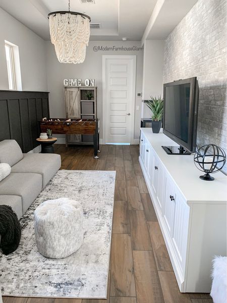 Gameroom at Modern Farmhouse Glam  Large white media console table, neutral area rug, black and white distressed rug, beaded Chandelier, Wooden bead lighting, foosball table, black accent table, matte black vase, white vase, peel and stick brick wallpaper, cabinet, storage, accent wall, family room furniture, home decor, living room, teen room 
Wayfair, Pottery Barn, Amazon home

#LTKkids #LTKhome