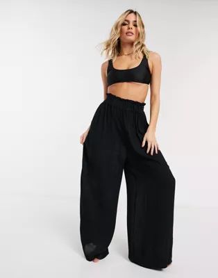 ASOS DESIGN crinkle wide leg palazzo beach pants in black | ASOS (Global)