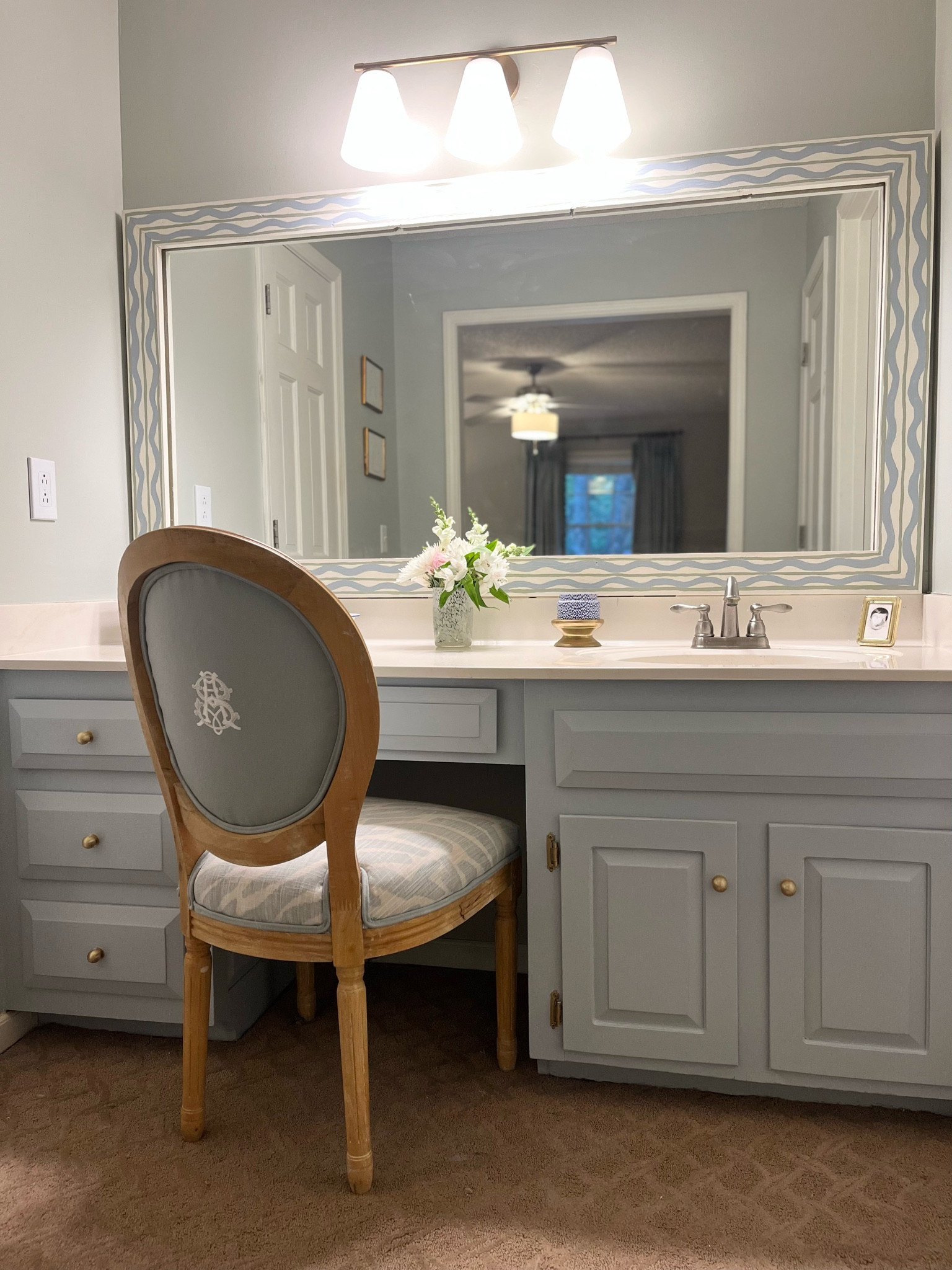 I usually just have the fabric curtain for this vanity, but sometimes you need to sit! I customized  thrifted chair by having the fabric redone and putting a monogram on the back. The mirror was made with wood cut into a frame and painted in a similar pattern to the fabric. 

#LTKhome