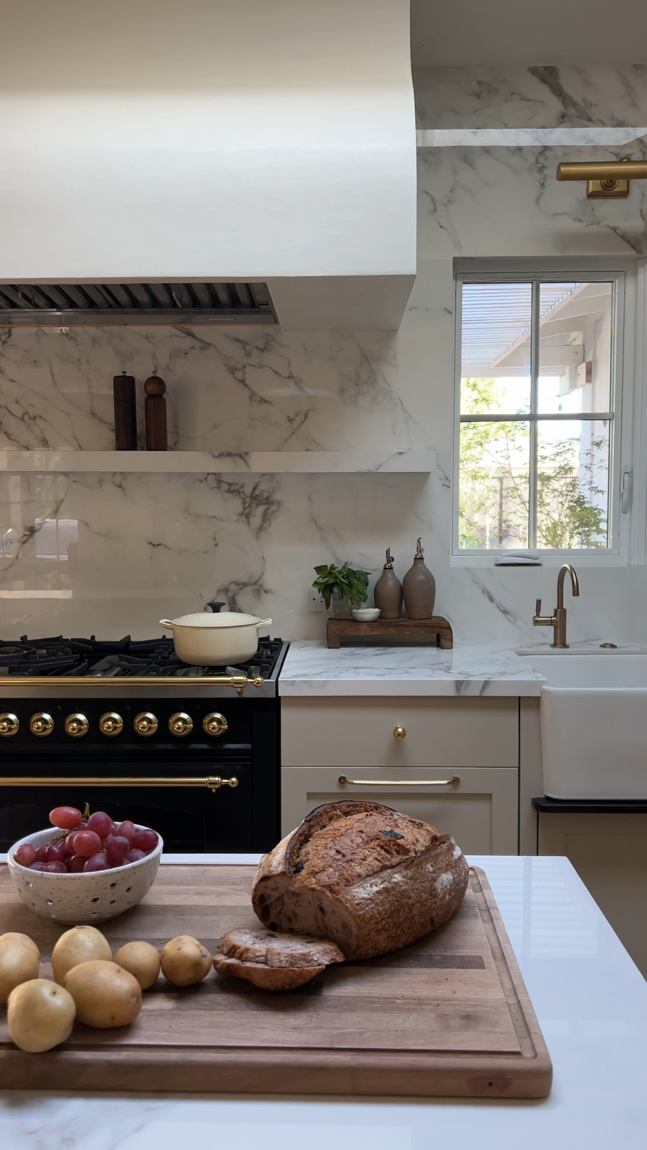 Kitchen decor, cream pendant lights, white pendant lights, brass pendant lights, red sweater, wood cutting board, artichokes, Amazon, visual comfort, wood salt and pepper mill, salt and pepper shaker, wood counter stool, plaster pendant brass sconce picture light olive oil 