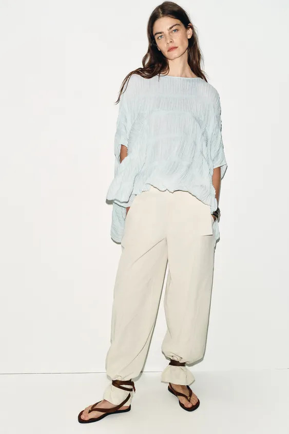 Round neck top with cape sleeves. Textured fabric and ruched detail. Asymmetric hem. | Zara US