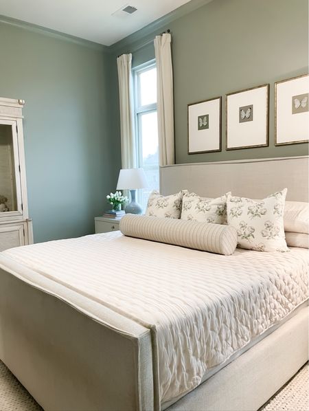Master bedroom neutral bedding, garden green walls, white nightstands, linen upholstered bed and floral pillows 

#LTKhome