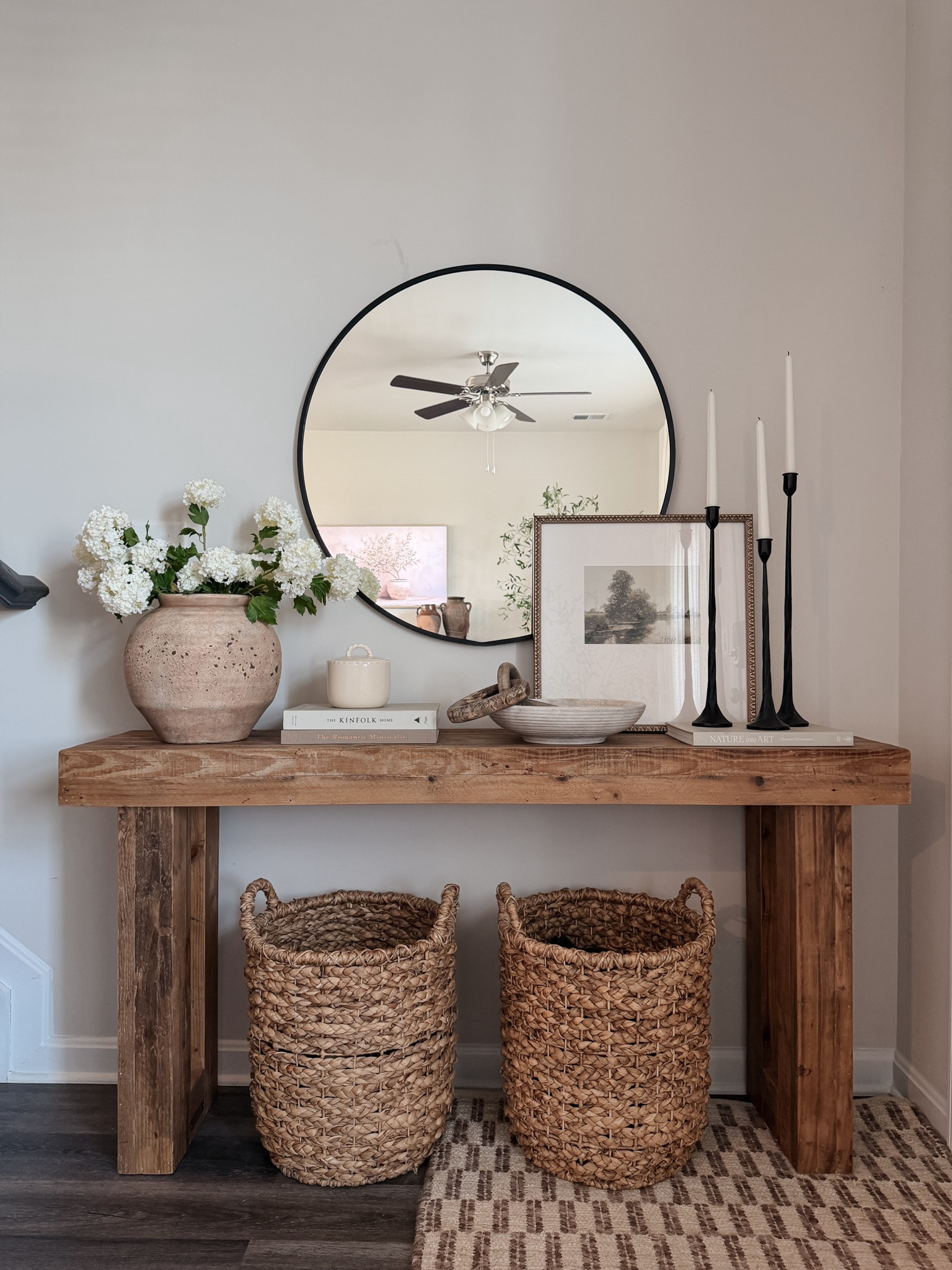 Simple console table styling 🤍 solid wood console table from Amazon, spring stems, round wall mirror, layered art, iron candle sticks, woven baskets, simple decor, affordable decor

#LTKSaleAlert #LTKSeasonal #LTKHome