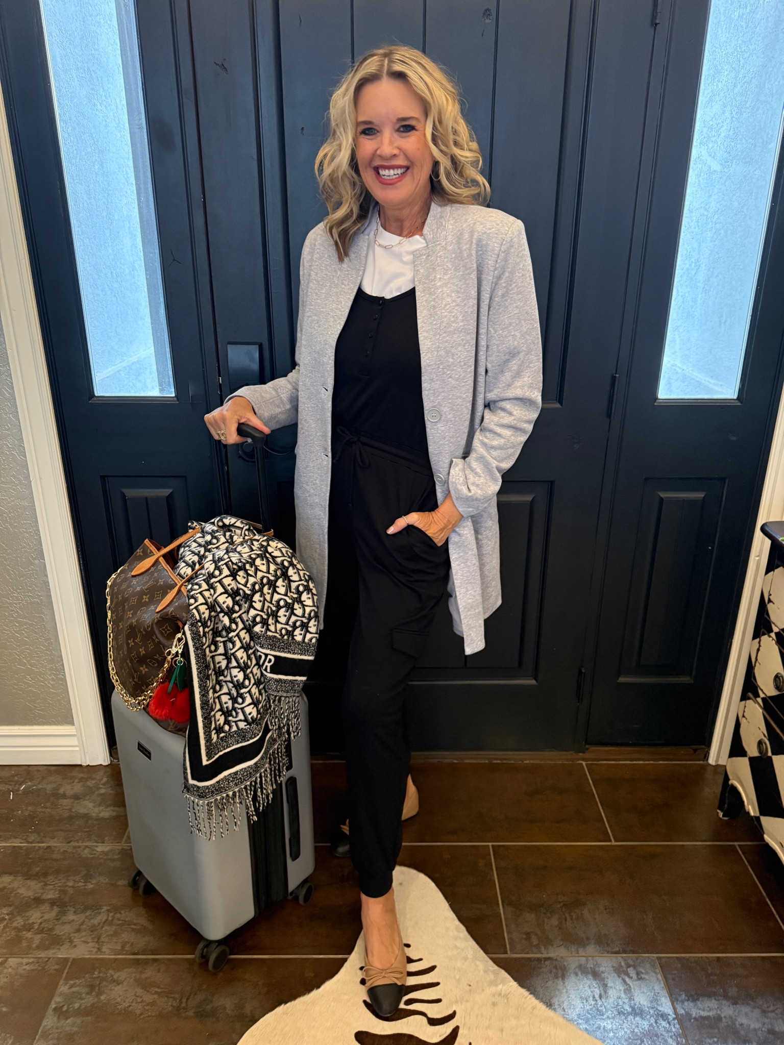 Travel outfit style
Gibsonlook 

Save 10% with code DARCY10 


Mid length light weight coat fits tts I am in a med 
Soft and jersey feel 

Gibsonlook black jumpsuit that ties at waist and has pockets  
Tts in a small 

White tee shirt bodysuit by spanx tts in a med

Cap toe ballet flat 

Vera Bradley luggage 

Dior scarf 

Louis Vuitton never fun large

Bag charms anthropology 

Gold hoops Kendra Scott
Cross necklace Kendra Scott 
Paper clip chain cart gold jewelry (linked costume jewelry look alike bauble bar) 

Apple Watch Michelle watch band
