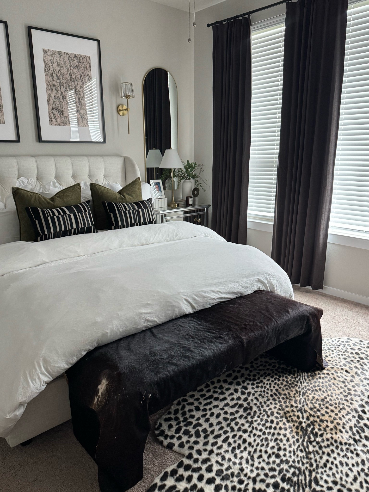 A little moody, a little luxe 🖤 I’m obsessed with how the black accents, soft neutrals, olive pillows + leopard rug came together to make our bedroom feel like a boutique hotel. Linking all the details on LTK 🤎 

master bedroom, bedroom decor, bedroom inspiration, bedroom ideas, modern bedroom, moody bedroom, luxury bedroom, luxury bedroom decor, elevated bedroom, hotel inspired bedroom, boutique hotel bedroom, neutral bedroom, neutral home decor, black and white bedroom, black bedroom decor, black curtains, black drapes, ivory bedroom, olive green decor, olive green pillows, velvet pillows, velvet throw pillows, leopard rug, leopard print rug, animal print rug, statement rug, bedroom rug, upholstered bed, upholstered headboard, bedroom bench, black bench, bedroom lighting, wall sconce, brass sconce, brass lighting, arched mirror, bedroom mirror, modern mirror, framed art, bedroom wall art, neutral wall art, layered bedding, white bedding, duvet cover, cozy bedding, luxury bedding, bedroom styling, home styling, interior design, home decor, modern home, contemporary home, transitional decor, organic modern, moody home, sophisticated home, cozy bedroom, primary bedroom, primary bedroom decor, bedroom makeover, home inspiration, LTK home, LTK finds, Amazon home decor, bedroom finds

#LTKSeasonal #LTKHome #LTKSaleAlert
