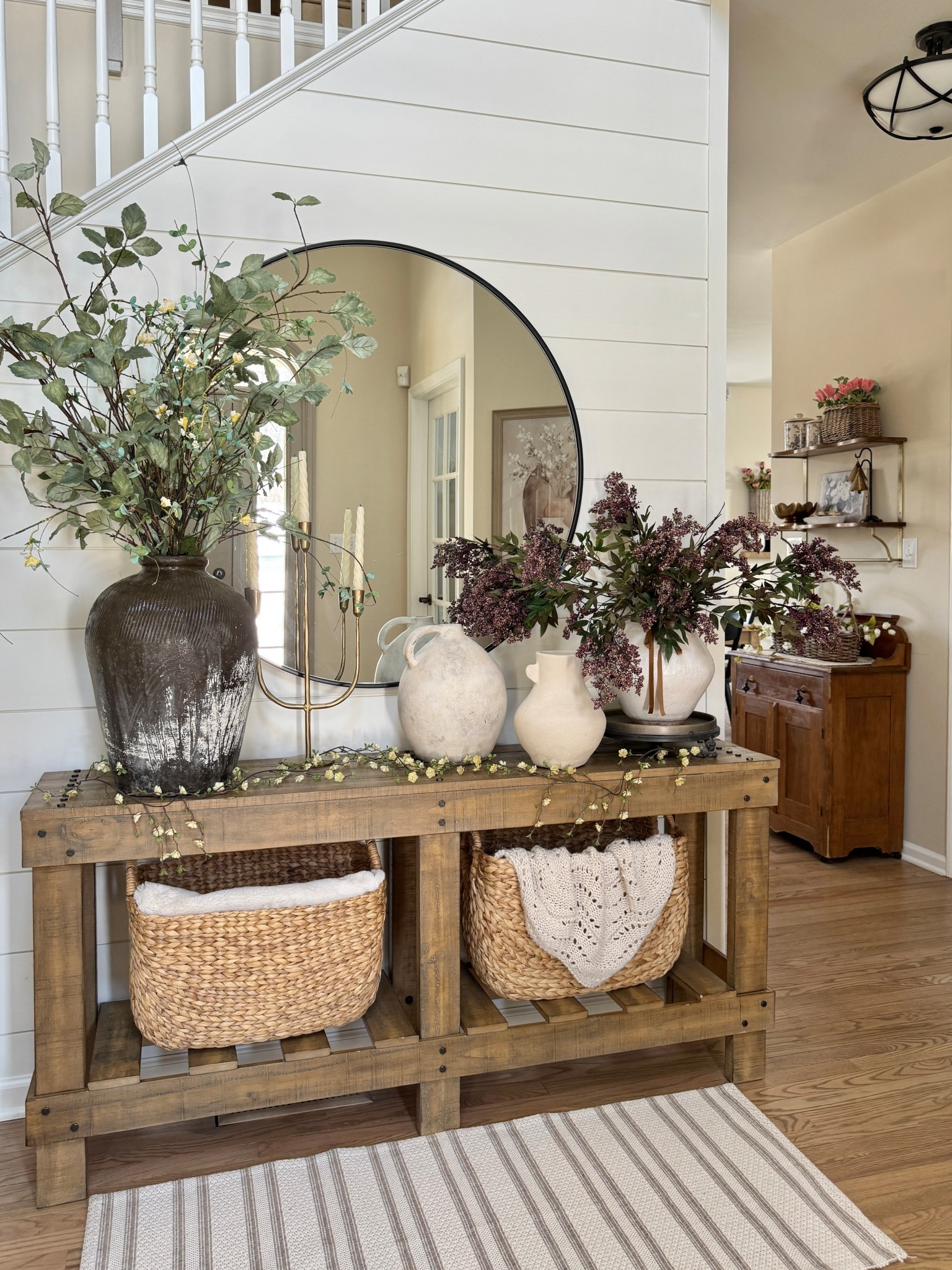 Entryway decor ~

Large textured rice wine decorative jar

Tall sage stems

French country iron pedestal tray

Tall narrow baskets

42” round wall mirror 

White vases

Candelabra

Entryway table

#LTKHome #LTKSaleAlert