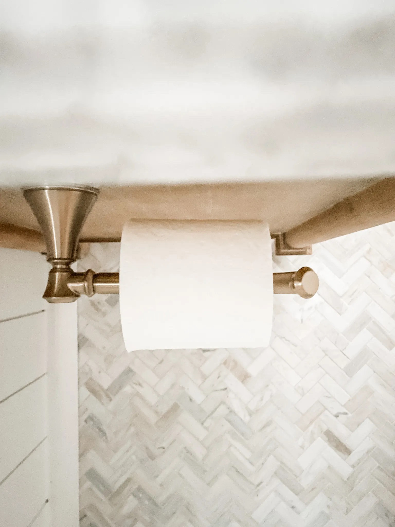 Powder room decor.
Our natural wood vanity in our Powder room is back in stock! 

Champagne bronze toilet paper holder, wall mount toilet paper holder, herringbone floor tile, polished marble floor and wall tile, neutral powder room floor tile. 
#bathroom #powderroom #tile 

#LTKhome #LTKFind #LTKstyletip