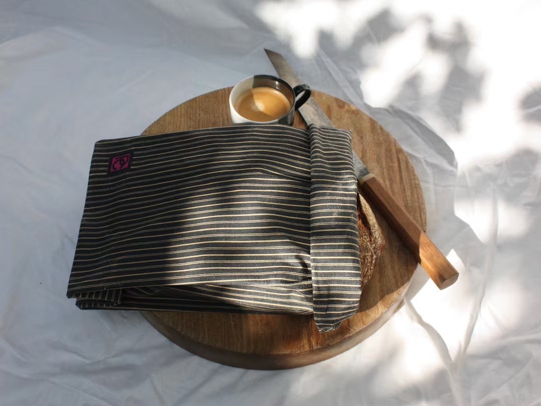 Keep your bread fresh the sustainable way with handcrafted Bread Bags from PeckhamCloth! Made, printed, and waxed by hand in Peckham, London, these reusable, biodegradable bags are crafted from organic cotton, pure beeswax, organic jojoba oil, and pine resin for antibacterial properties and a natural grip. Perfect for sourdough or traditional loaves, each bag (29cm x 49cm) helps maintain freshness and a crisp crust. Washable like beeswax wraps, they can be reused time and time again. Plus, for every product sold, we plant a tree—combining practicality with a positive environmental impact.

#SustainableLiving #BreadBag #EcoFriendlyKitchen #PeckhamCloth #ReusableProducts #HandmadeInLondon #EtsyFinds #ZeroWaste

#LTKGiftGuide #LTKFindsUnder50 #LTKHome