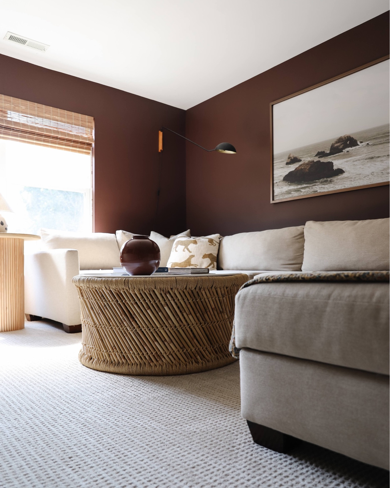 Family room, woven round coffee table, large art, black sconce

#LTKHome