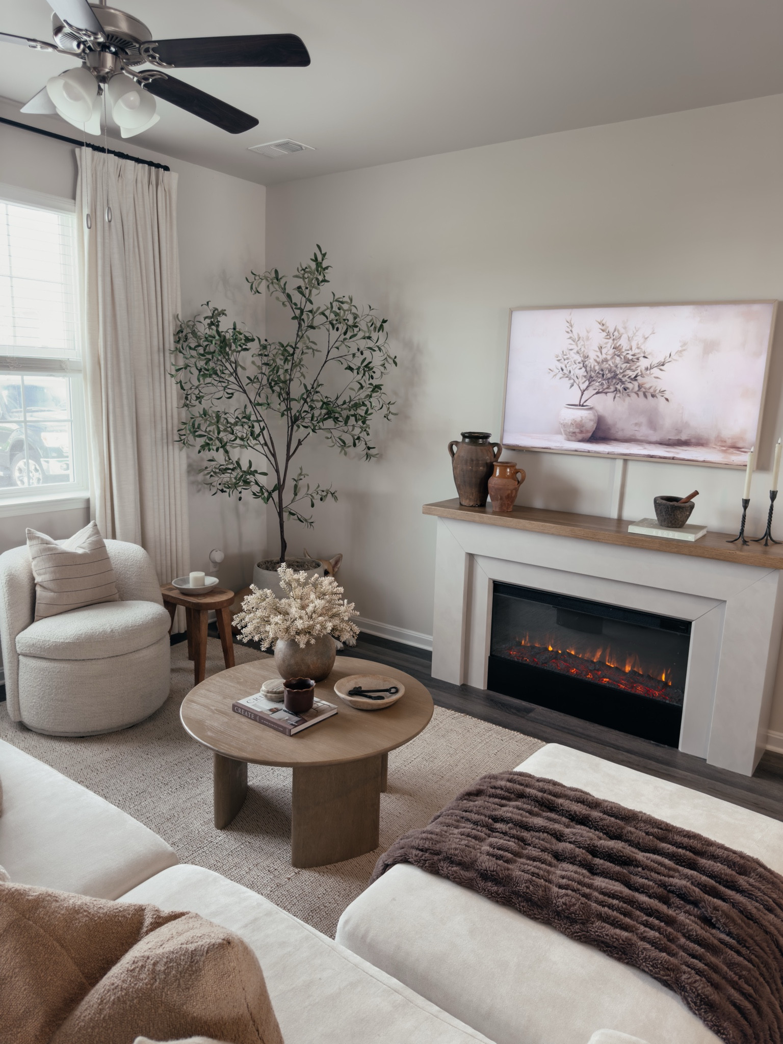 Living style, neutral rug, malie fireplace, olive tree, designer style, frame tv, world market coffee table, round coffee table, organic vase 

#LTKHome #LTKSaleAlert