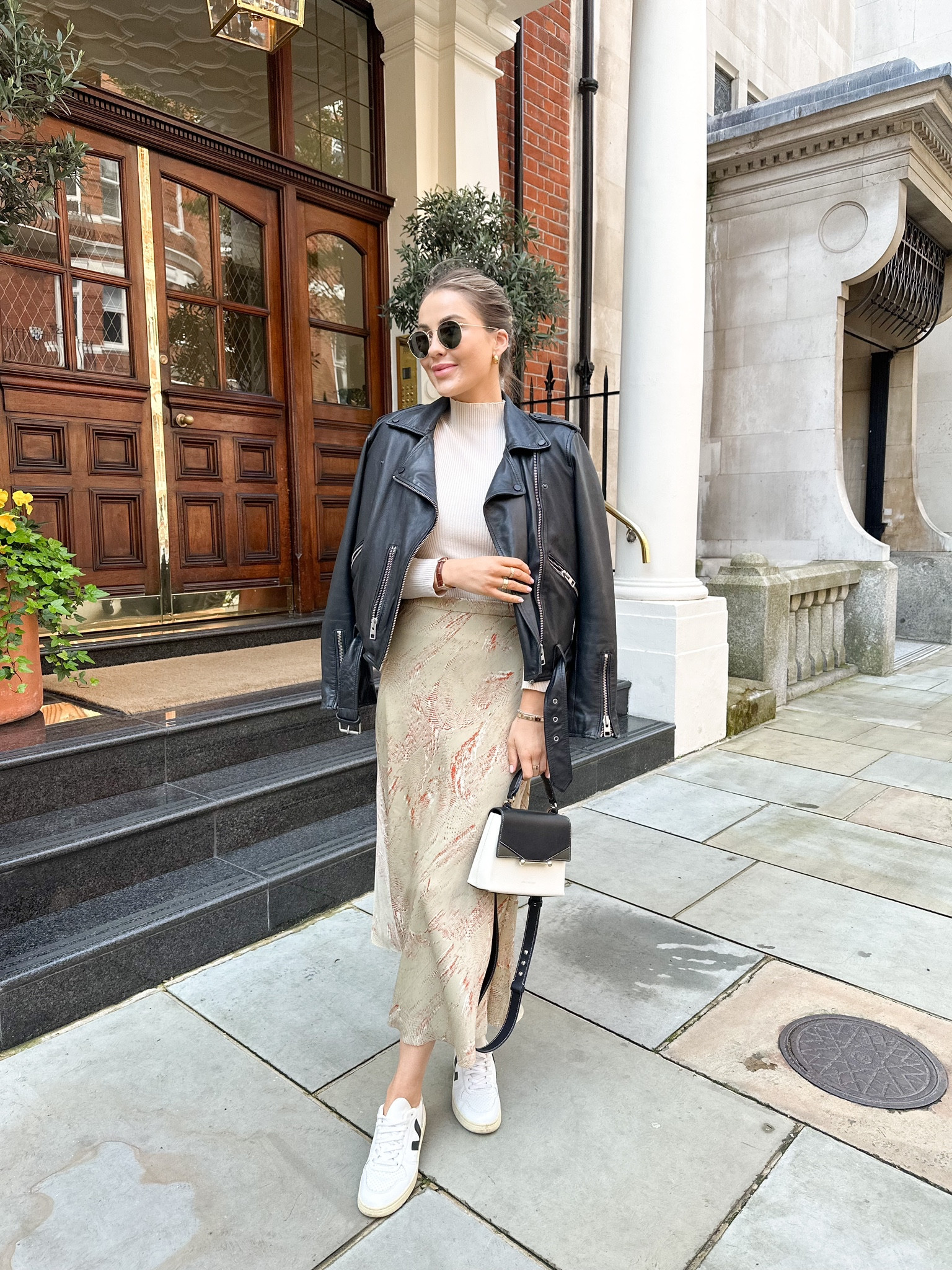 Classic spring outfit - snake print satin midi skirt (similar linked), allsaints leather jacket, mock neck ribbed beige top, black & white veja v10 trainers, top handle handbag & rayban round sunnies

#LTKstyletip #LTKeurope #LTKSeasonal