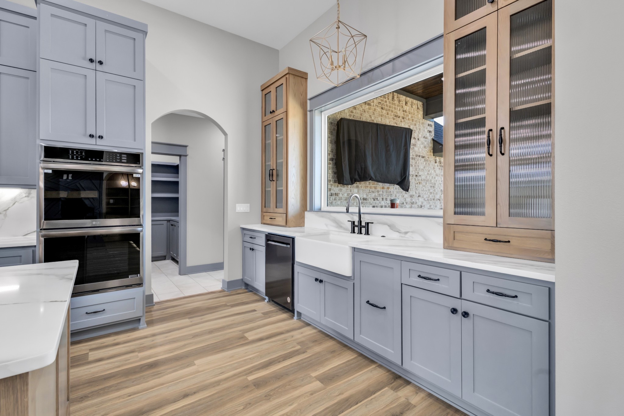 Modern farmhouse kitchen details ✨

Linking everything from this space the statement gold geometric pendant light, Delta matte black kitchen faucet, classic white farmhouse apron-front sink, LG double wall oven, Delta garbage disposal air switch, and matte black cabinet hardware.

I love mixing warm wood cabinetry with soft gray cabinets for contrast, and adding timeless finishes that feel custom but still functional for everyday life. These are all builder-approved favorites that elevate a new construction kitchen instantly.

Save this for your kitchen remodel inspiration 🤍

#LTKhome #ModernFarmhouseKitchen #KitchenInspo #FarmhouseSink #DeltaFaucet #LGCooking #KitchenDesign #CabinetHardware #NewConstruction #BuilderFavorites