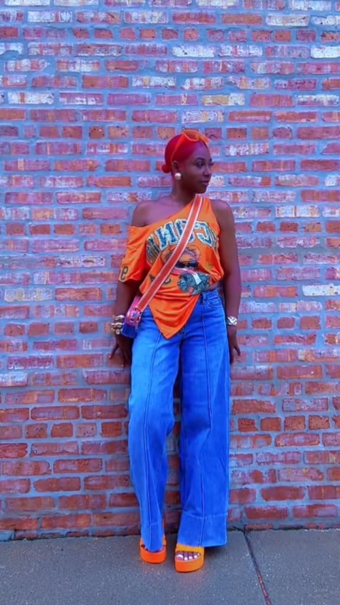 Color does the talking.
An oversized orange graphic tee styled off-shoulder with wide-leg jeans and platform sandals for an effortless statement look. Comfortable, bold, and styled with intention.

#LTKootd