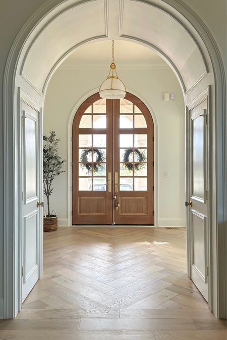 Norfolk pine wreath, hanging iron bells, arched front door, pendant light 

#LTKSeasonal #LTKHoliday