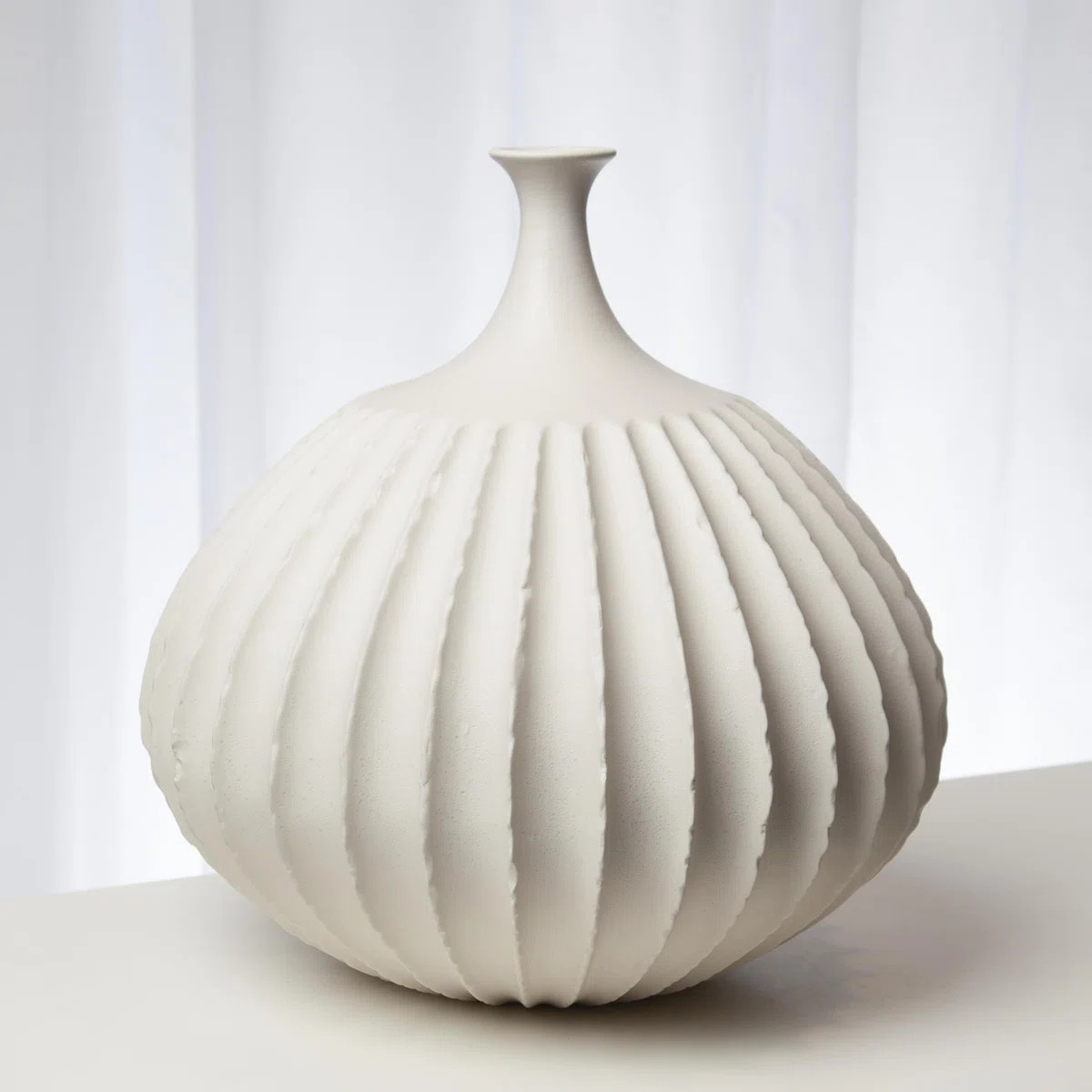 Crisp, symmetric ridges accentuate the rounded shape of the Sawtooth Vase. Textured, matte white ... | Wayfair North America
