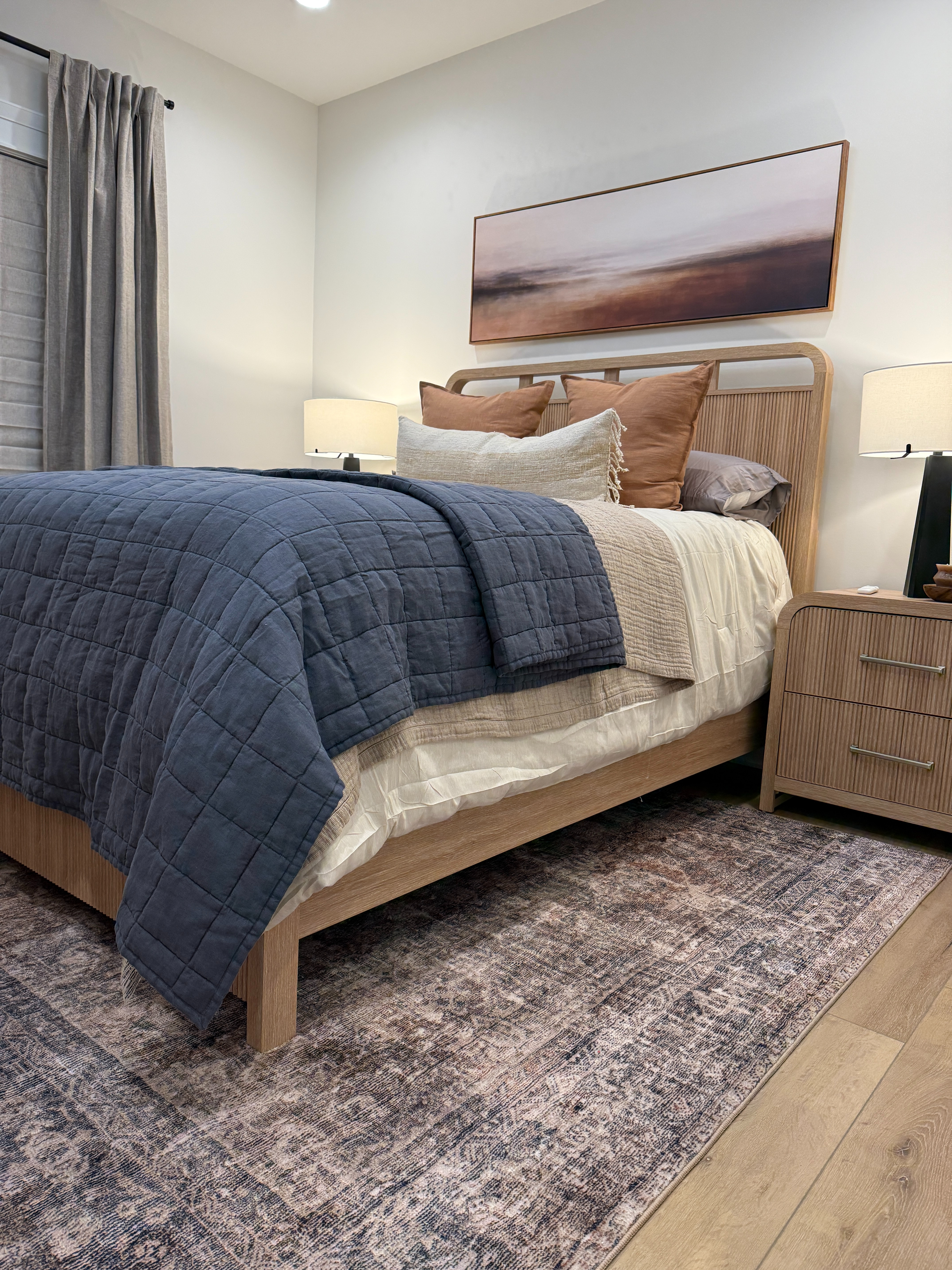 Guest Bedroom Design: We came into a space with existing furniture and our job was to give it a cohesive look that would be both functional and comfortable for guests. Layered bedding in different colors and textures add a ton of visual interest to an otherwise simple bed frame. Dark lamps and a rug that (truly) ties the room together.  

 #LTKHome
