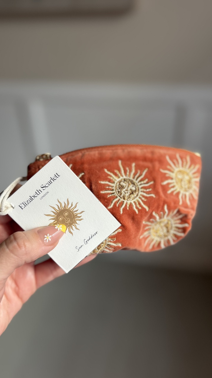 Keep your smaller treasures safe and stylish, with a golden zip that makes paying for your morning coffee a little more joyful. Featuring Elizabeth's hand-drawn sun motif, embroidered in vanilla and gold threads with a human-like face that imagines our most powerful star as a gentle being radiating warmth and light. #elizabethscarlet

#LTKMothersDay #LTKmomlife