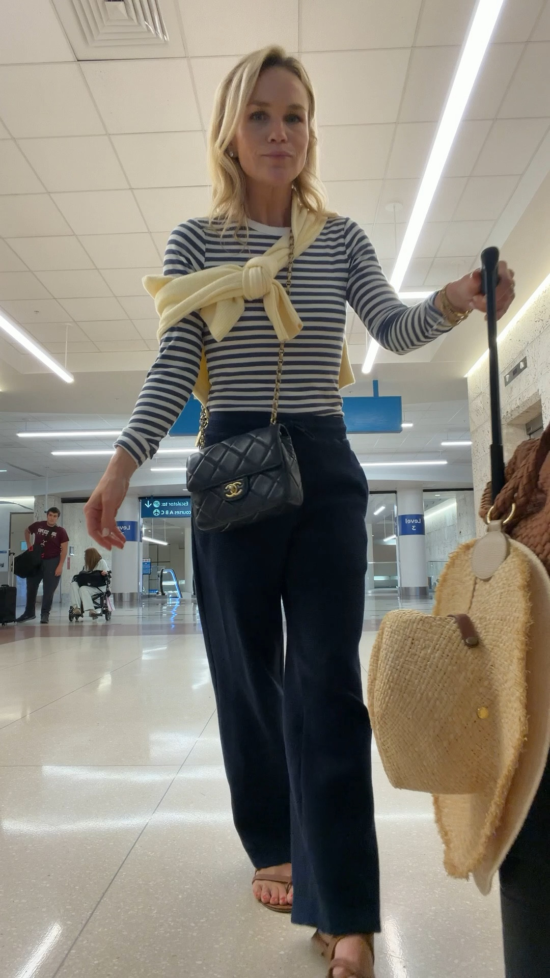 @Vivrelle navy Chanel bag 
Negative navy blue waffle knit lounge pants 
Yellow @Tuckernuck sweater 
Striped tee shirt away suitcase 
Manolo sandals 
Airport outfit 

#LTKTravel #LTKootd