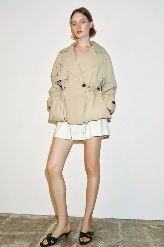 Cropped trench coat with lapel collar and long sleeves with buttoned tabs. Front pockets. Adjusta... | Zara US