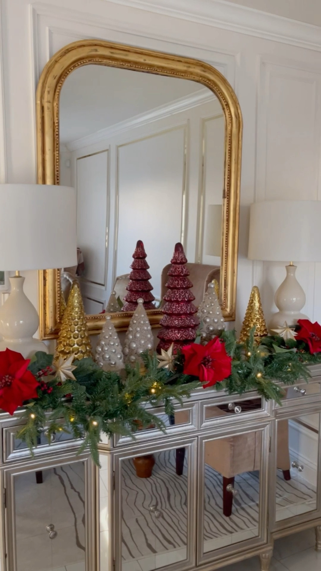 Sideboard Christmas styling. Mercury glass red, gold trees. Bottle brush trees, green pine garland, red velvet poinsettia and red berries. 

#LTKhome #LTKSeasonal #LTKHoliday