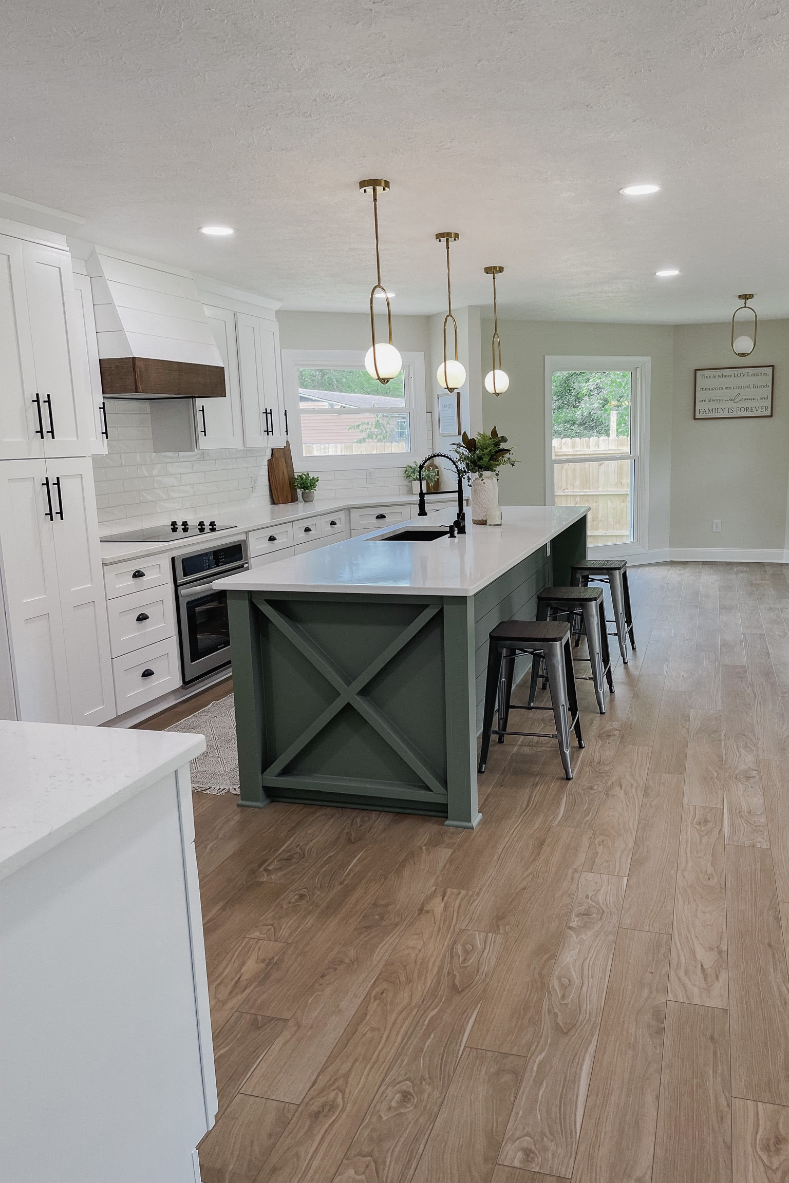 Kitchen remodel // kitchen renovation// green cabinets // pulls // knobs // cups // light fixtures // gold pendent // cooktop // in-wall oven // island 