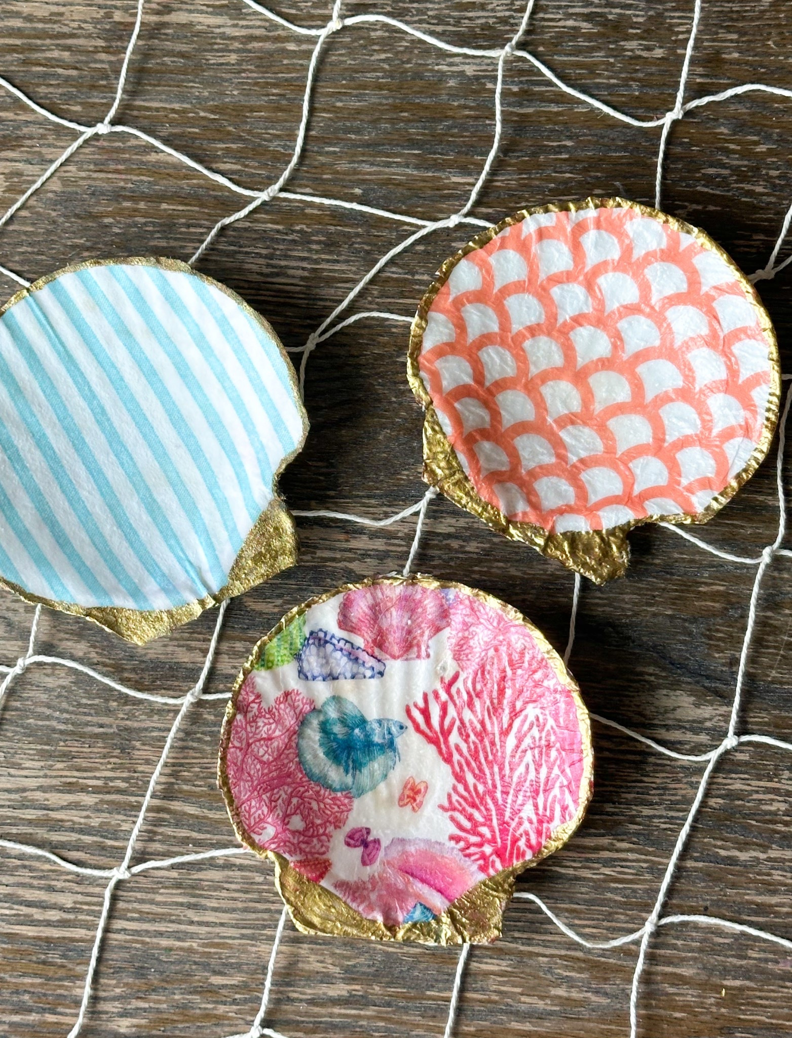 These DIY seashells are soooo fun and sooo easy to make! Linking everything you need! 
Paint the inside of your shell with a layer of Mod Podge, open your napkin so you’re just using the single layer with the pattern, place it on the shell and smooth it out with your finger tips, add a light layer of Mod Podge over the napkin and let dry for an hour or so. Slowly oil or cut the excess napkin and paint the edges with antique gold paint! 🐚

#LTKHome