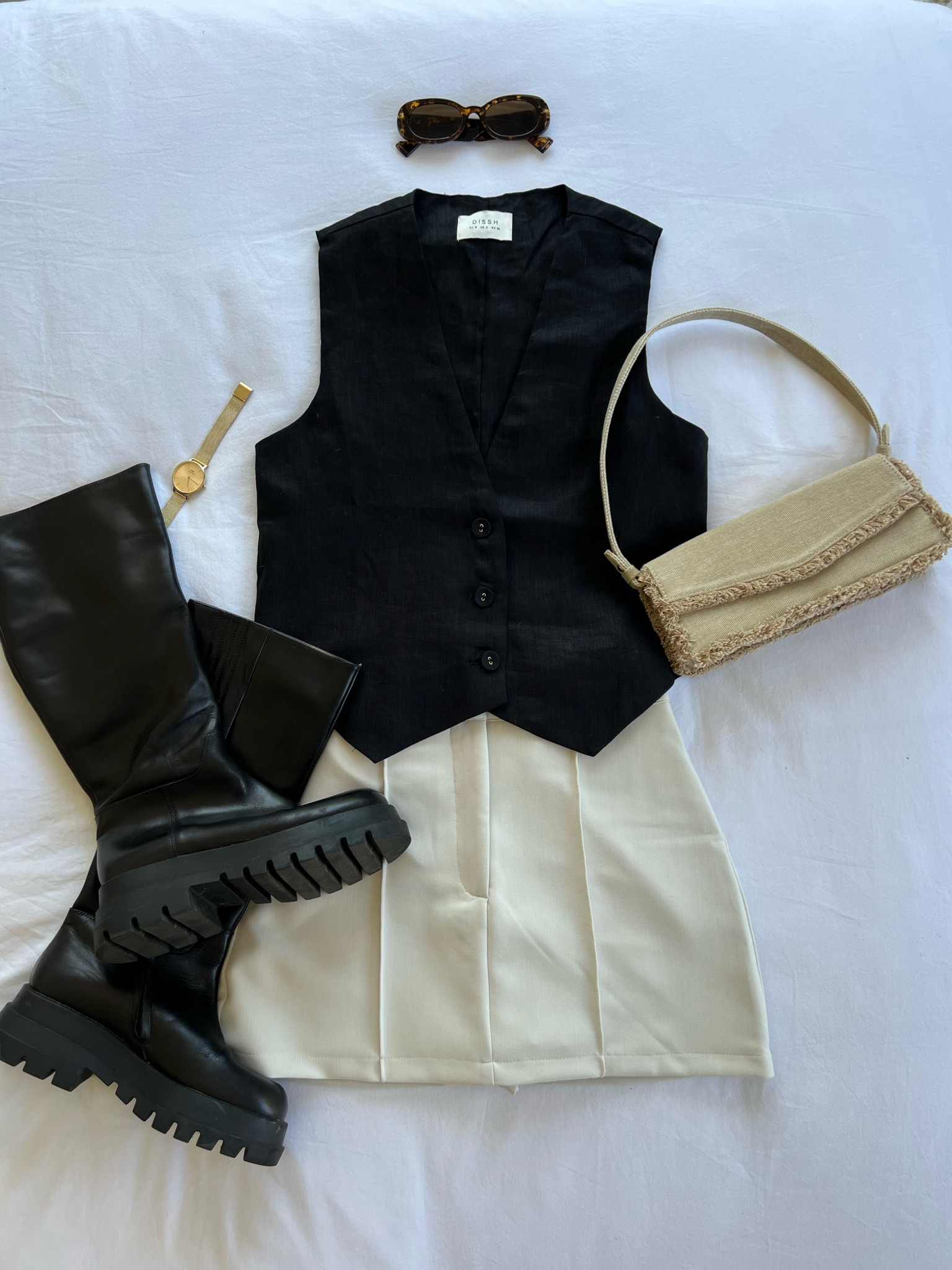 Chic minimalist outfit for spring - black linen vest, cream mini skort, alias mae boots, zara frilled bag