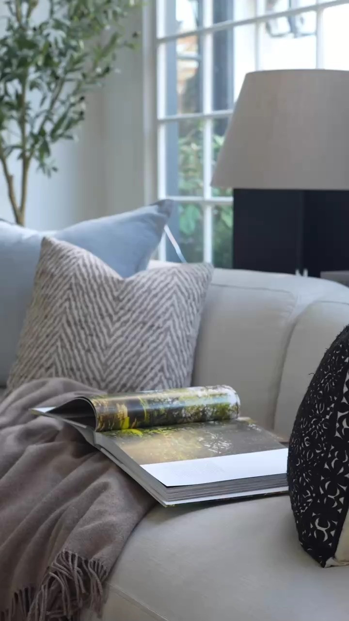 OMG nothing makes me happier than curling up on the couch with a book while the candle flickers and the living room feels extra cozy. The stacked coffee table books, soft neutral tones, and timeless blue and white decor create the most relaxing home styling moment. WOW this is the kind of peaceful, cozy interior design vibe I could stay in forever.  

 #LTKdayinmylife #LTKSeasonal #LTKHome