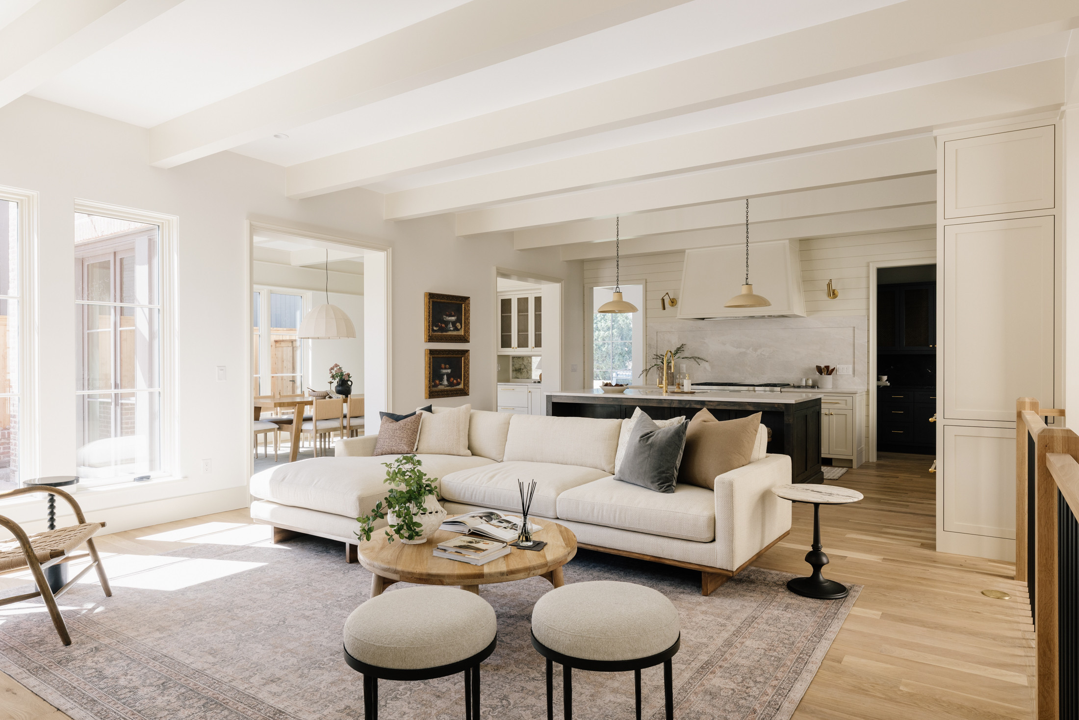 Cream sectional styled with a light wood coffee table, accent stools, and an antique-inspired rug for a timeless, inviting feel.

living room, sectional, sofa, ottoman, rug, neutral 

 #LTKHome