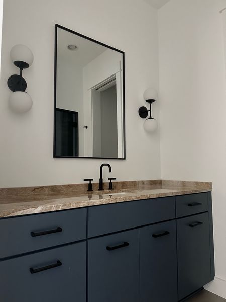 Bathroom Details | Navy Cabinets | Matte Black Hardware | Kohler Faucet | Mirror | Wall Sconces 

#LTKhome #LTKstyletip