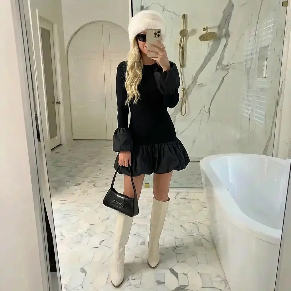 
A stylish mirror selfie in a bright marble luxury bathroom with soft natural lighting. A tall, elegant blonde woman wears a fitted black mini dress with long sleeves and a subtle ruffled hem, creating a sleek yet playful silhouette. She pairs the look with cream knee-high boots, a small black shoulder bag, oversized black sunglasses, and a fluffy white winter hat for contrast. Her hair falls in loose, polished waves, and the overall aesthetic feels modern, minimalist, and effortlessly chic — blending quiet luxury, winter fashion, and confident main-character energy.

⸻

HASHTAGS

#WinterChic
#QuietLuxury
#BlackDressMoment
#CoolGirlStyle
#MinimalistFashion
#LuxuryAesthetic
#ModernElegance
#WhiteBoots
#SoftGlam
#MirrorOutfit
#EffortlessChic
#ColdWeatherStyle
#TimelessFashion
#OldMoneyVibes
#OOTD
#NeutralLuxury
#MainCharacterEnergy
#ChicMinimalism
#FashionInspo
#WinterStyle

If you want, I can:

#LTKHoliday #LTKdayinmylife #LTKGiftGuide