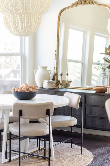 Our neutral breakfast nook features a wood bead chandelier, round white dining table, leather dining chairs, round jute rug, black cane sideboard and gold Primrose mirror. The windows are curtainless to allow for as much light as possible with the Alabaster wall paint. home decor dining room decor faux magnolia white stoneware vase

#LTKhome #LTKstyletip #LTKfamily