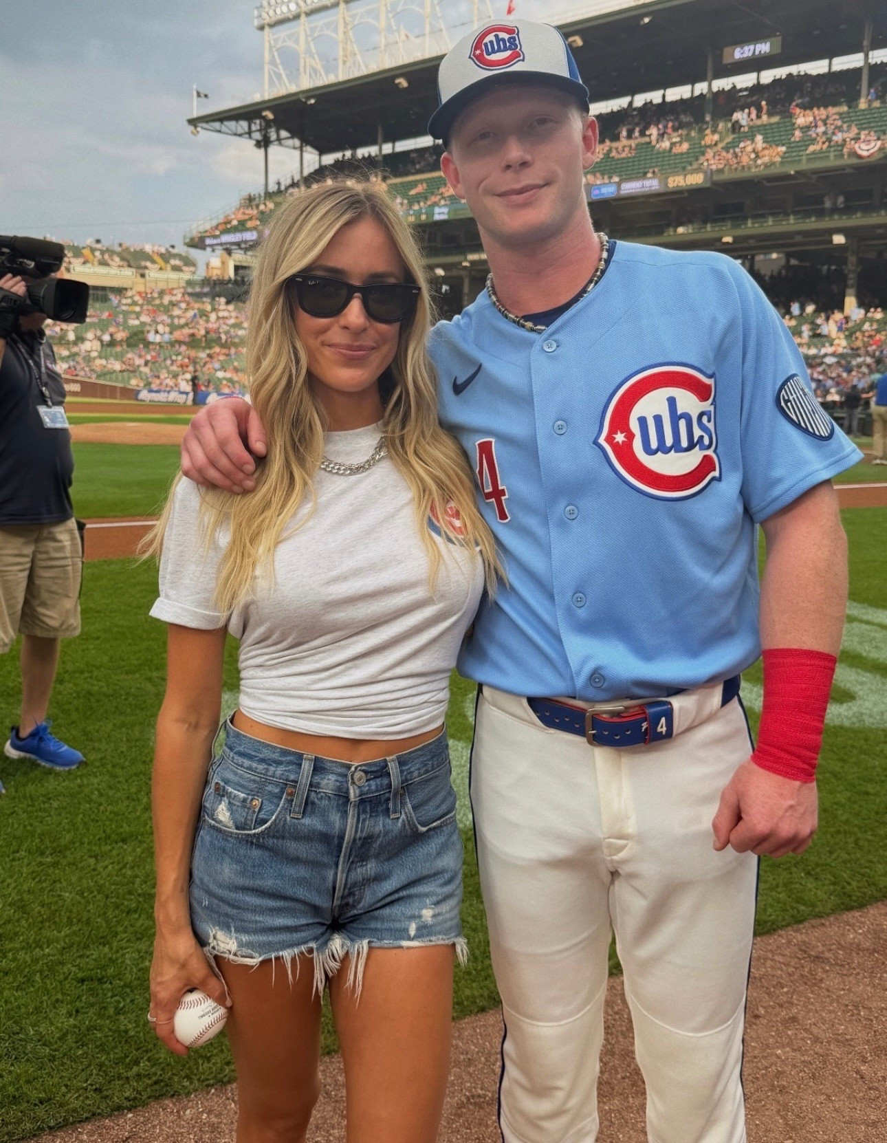 Kristin Cavalleri wears denim cut off shorts, square black sunglasses ￼