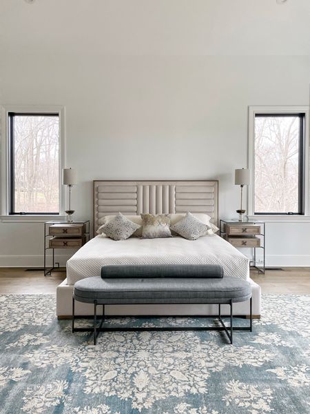 This bedroom gives a warm modern views. Contemporary shapes on the bed and bench paired with the softness of the traditional rug and nightstands