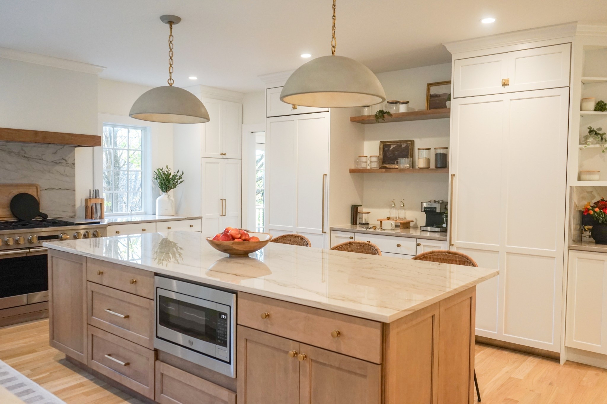 Hidden appliances, visible style. This back-of-island view shows off the clean cabinetry lines, a built-in microwave, and a beautiful pendants. 
