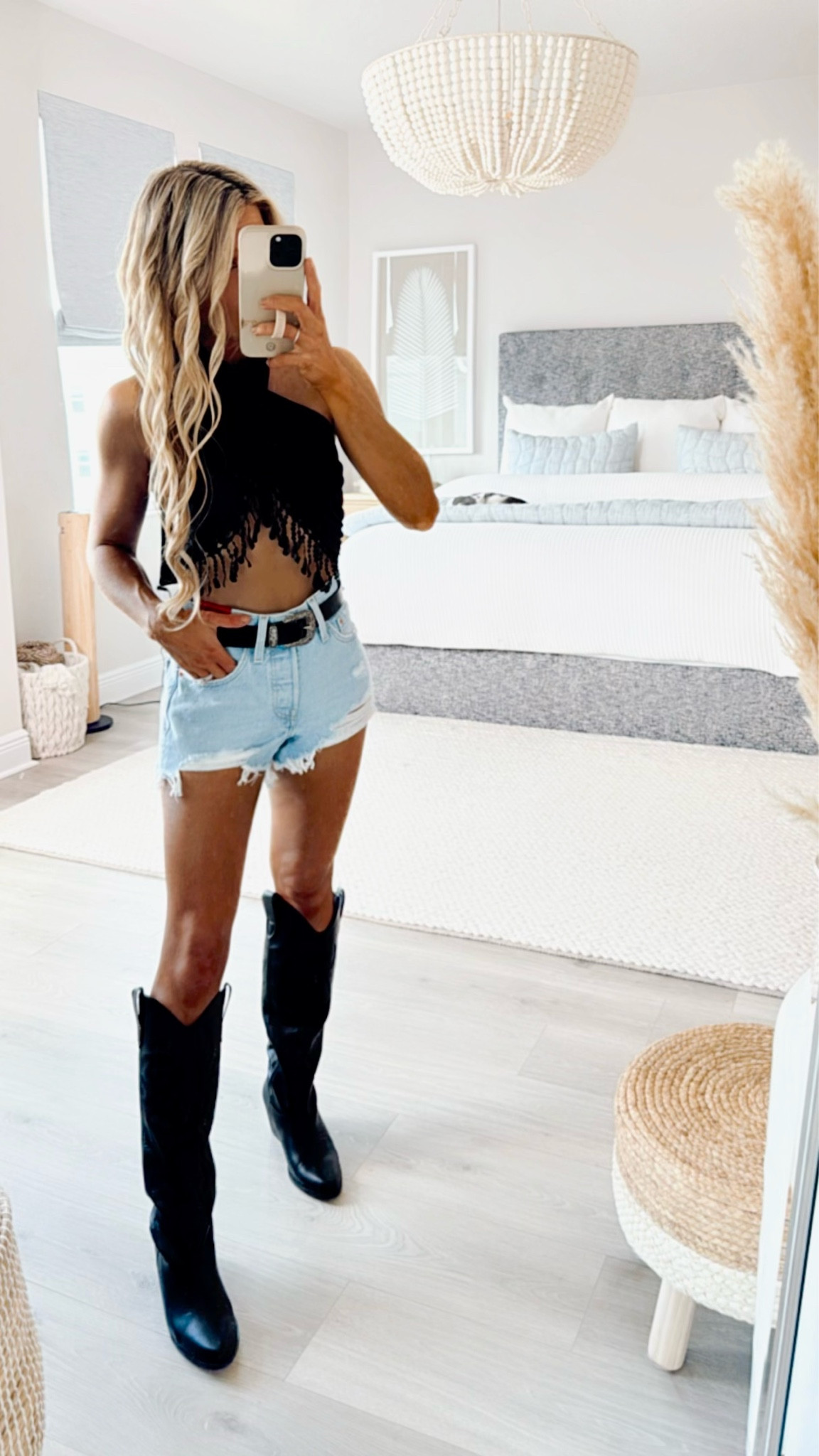 Country Concert Outfit 🤠✨ This western outfit from Amazon is perfect for your next country concert, music festival, Nashville trip, or bachelorette party! It would also make a cute cowgirl costume for Halloween! 

I’m wearing this country outfit to a Morgan Wallen concert. The black halterneck top wraps so you can tie it to ensure the perfect fit. The bottom of this black top has a fringe detail that gives western vibes. I paired it with my favorite pair of denim shorts. These denim shorts are high waisted, lightwash, and distressed. I am wearing black cowgirl boots that are a designer look for less. I added a western belt, black cowgirl hat, and black fringe purse to match  #LTKHalloween

#LTKStyleTip #LTKFindsUnder50