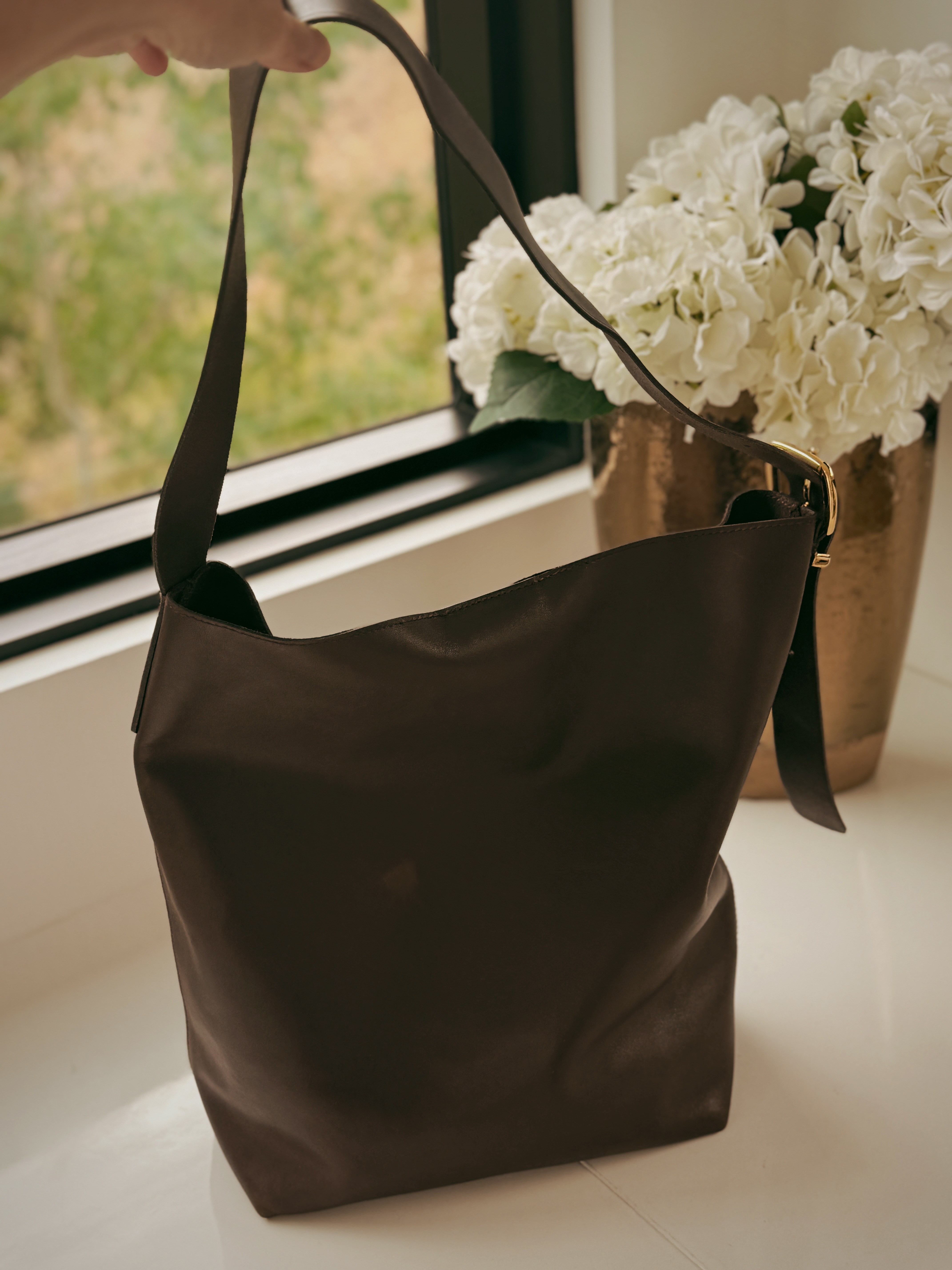 Here's what makes a great everyday tote; it has to be roomy without looking sloppy, structured without being stiff, and neutral enough to work with everything. 

This Madewell Shopper Tote in dark chocolate leather checks every single box. The wide flat straps sit comfortably on the shoulder and the gold buckle hardware keeps it feeling elevated.

#LTKgrwm #LTKOver40 #LTKSaleAlert