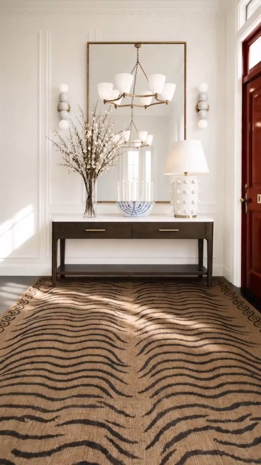 Start a new week with a refreshed entryway. ✨

As we head toward the holiday entertaining season, I love the idea of refreshing the entry with pieces that feel timeless, functional, and still very current.

The warm oak console brings such a classic furniture feel to the space, while the drawer storage makes it especially practical for an entry. Paired with a marble top, it feels polished and substantial without becoming too formal.

One of my favorite elements is the Arhaus Arren Mirror. The oversized scale reflects natural light and the chandelier while visually opening up the entry, making the entire space feel brighter, taller, and more expansive.

The soft fabric shades on the chandelier add another elegant layer. I love how the relaxed drape of the fabric softens the more architectural lines of the console and mirror.

And the zebra-inspired rug is what really modernizes the space. That bold animal-inspired pattern adds a chic, unexpected contrast to all of the classical elements, giving the entry a more fashion-forward edge while still keeping the overall look sophisticated and timeless.

If you’re planning an entryway refresh before the holiday entertaining season begins, now is a great time to shop the deep Labor Day sales on furniture, mirrors, lighting, rugs, and décor.

#Entryway #EntrywayDesign #EntrywayRefresh #ArrenMirror #StatementMirror #OakConsole #MarbleConsole #ZebraRug #AnimalPrintRug #StatementRug #Chandelier #FabricChandelier #WallSconce #ModernClassic #ModernChic #ClassicInteriors #TimelessInteriors #HolidayEntertaining #LaborDaySale #LaborDayDeals #InteriorDesign #HomeDecor #LTKHome #LTKSaleAlert

#LTKHome #LTKSaleAlert #LTKSeasonal