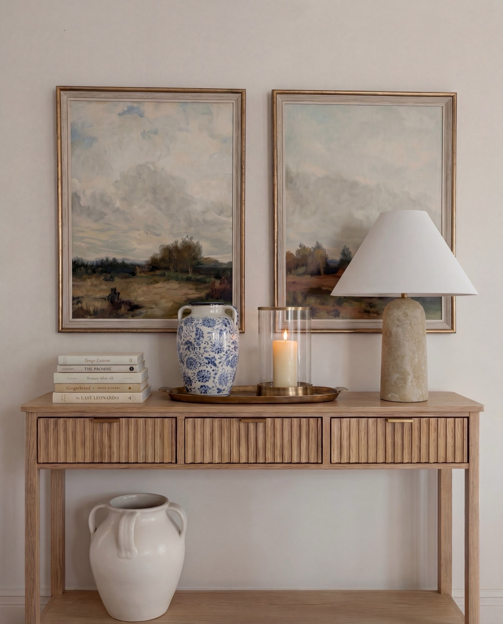 
Shop the Look:
• Dark wood rectangular dining table
• Curved ivory upholstered dining chairs (wood base)
• Blue ceramic decorative bowl (table centerpiece)
• Brass vase with dried branches
• Blue patterned area rug
• Light wood sideboard with fluted drawer detail
• Blue-and-white ceramic vase (sideboard)
• Neutral table lamp with white shade
• Stacked books + candle decor
• Framed landscape wall art (set of two)
• Dark wood arched china cabinet with glass doors
• White ceramic floor vase
• Exposed wood ceiling beams
• Soft blue ceiling paint
Tall blue floor vase 

#LTKHome #LTKSaleAlert #LTKSpringSale