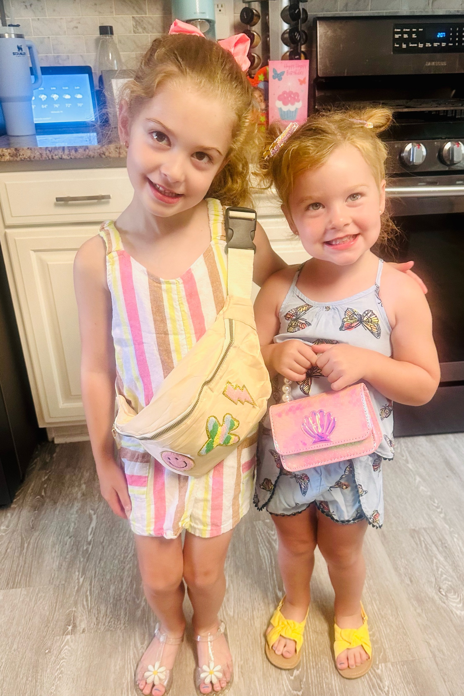 Sister sister! Cute, breezy, easy summer outfits for #toddlergirls #summeroutfits #littlegirlstyle 🩷 Ellie’s outfit is linked, the cutest little striped romper from #walmart & an #amazon emoji patched fanny pack. Faith’s outfit and purse are from a local boutique 👛 

#LTKkids #LTKBacktoSchool #LTKSeasonal