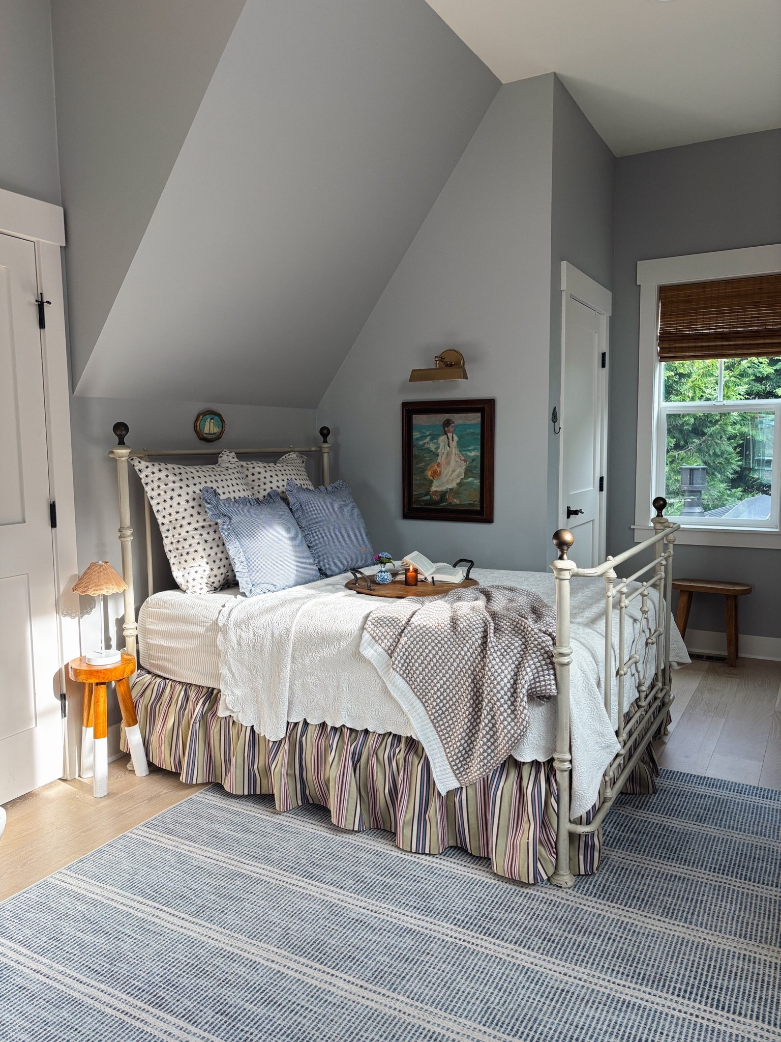 Cozying up the Snug - striped bedskirt, blue and white striped washable rug, gingham ruffle pillows, brass picture light, knit blanket, cordless lamp, stools, striped sheets, bamboo shades

#LTKSaleAlert #LTKHome #LTKSeasonal