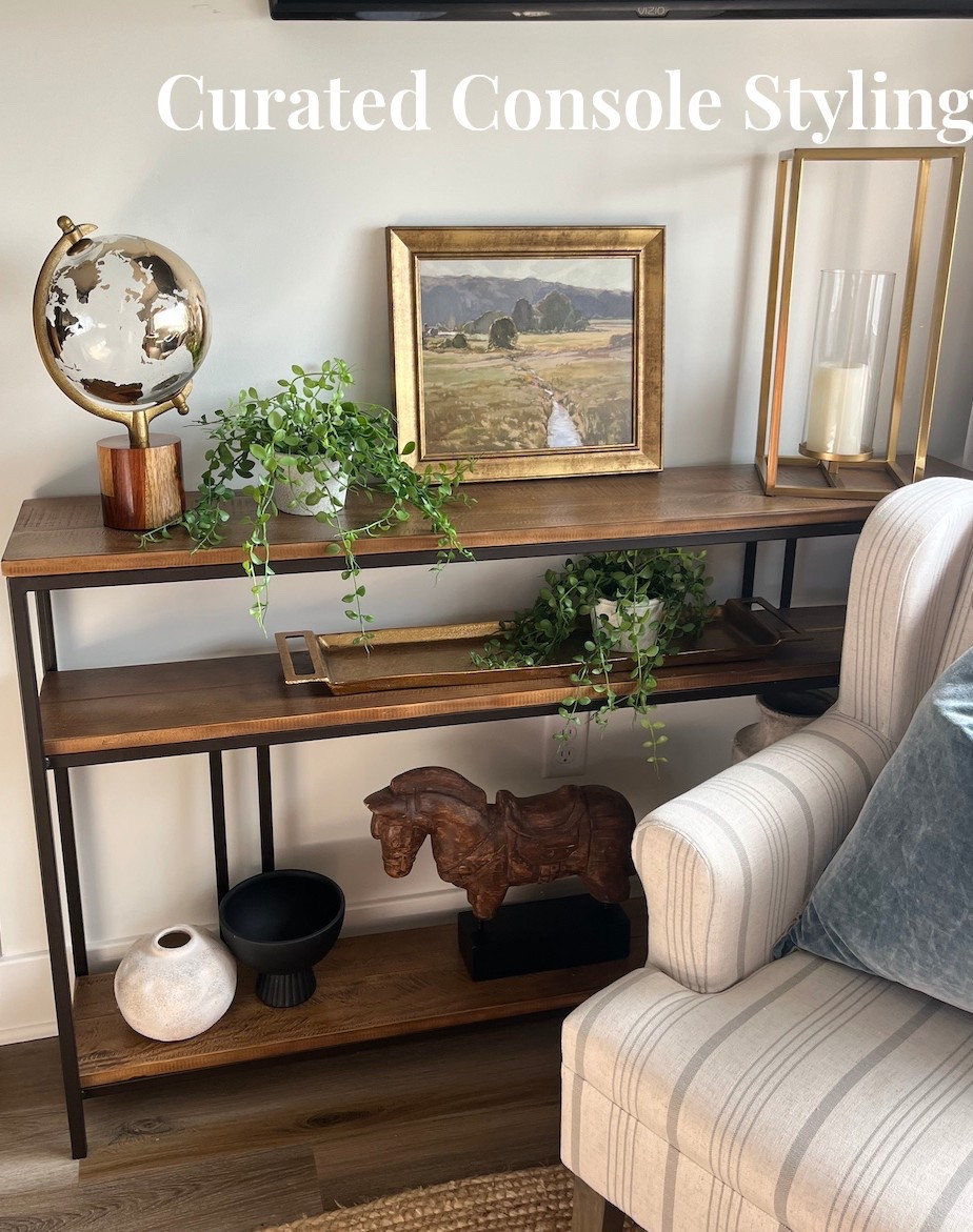 An Airbnb nook under the TV that strikes the perfect balance of warmth and sophistication. I layered gold accents, greenery, and sculptural pieces to bring depth and personality to this console table. The artwork ties it all together, creating a cohesive and welcoming focal point in the living room.

#ltkhome #consoledecor #entrywaystyling #airbnbluxury #modernclassic #interiordetails #amandaandcodesign

#LTKStyleTip #LTKHome